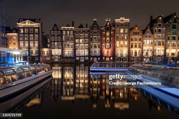 tour boats and architecture of amsterdam at night - amsterdam night stock-fotos und bilder