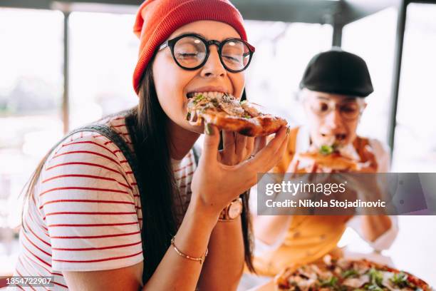 freundinnen essen pizza - italiener stock-fotos und bilder