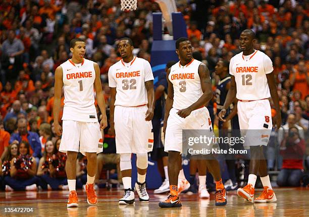 Michael Carter-Williams, Kris Joseph, Dion Waiters and Baye Keita of the Syracuse Orange walk on the court during the game against the George...