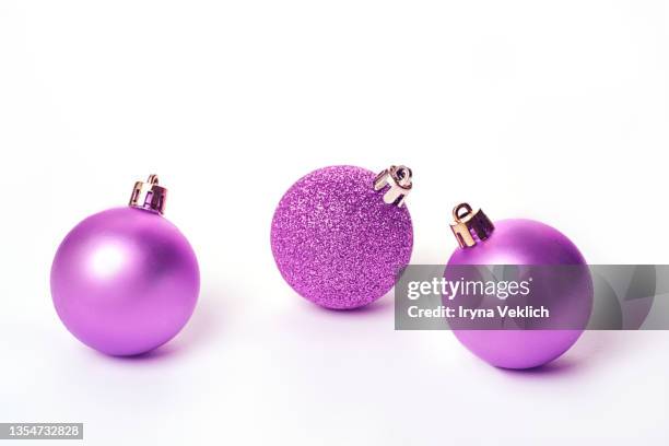 three christmas balls in trendy  digital lavender purple violet  color on white background. - esferas de navidad fotografías e imágenes de stock