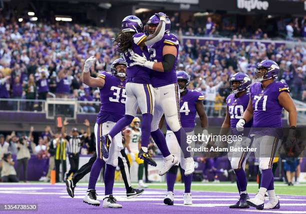 Dalvin Cook of the Minnesota Vikings celebrates with teammate Ezra Cleveland after rushing for a touchdown against the Green Bay Packers in the first...