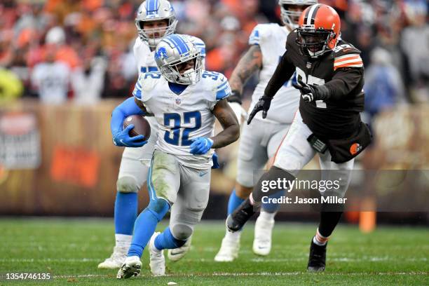 Andre Swift of the Detroit Lions runs with the ball past Malik Jackson of the Cleveland Browns in the third quarter at FirstEnergy Stadium on...