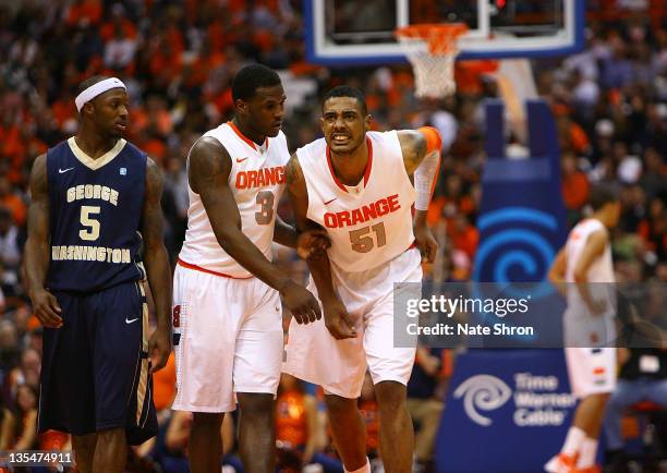 Fab Melo of the Syracuse Orange limps off the court after an injury as he is assisted by teammate Dion Waiters as Bryan Bynes of the George...