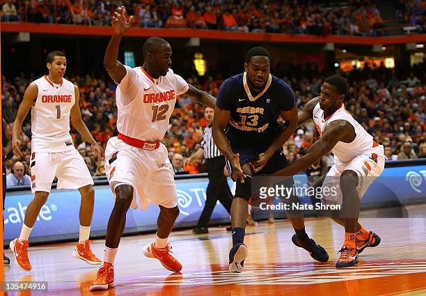 Jabari Edwards of the George Washington Colonials loses the ball to Dion Waiters of the Syracuse Orange with the help of teammate Baye Keita during...