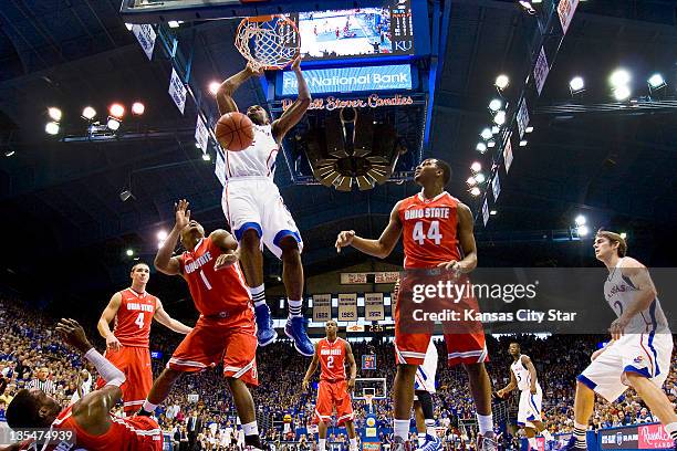 Kansas' Justin Wesley bowls over Ohio State's Evan Ravenel for a two-handed dunk during the first half at Allen Fieldhouse in Lawrence, Kansas,...