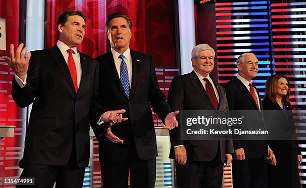 Texas Gov. Rick Perry talks with former Massachusetts Gov. Mitt Romney, while former Speaker of the House Newt Gingrich, U.S. Rep. Ron Paul , and...