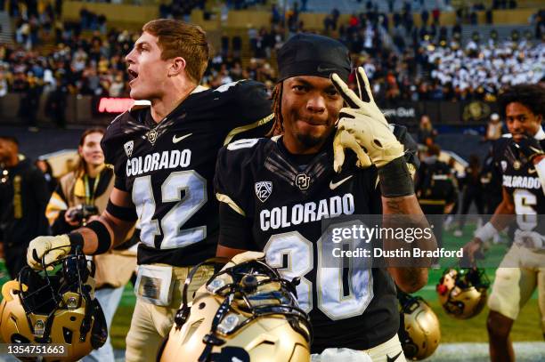 Safety Curtis Appleton II and safety Trevor Woods of the Colorado Buffaloes on the field as players celebrate a 20-17 win over the Washington Huskies...