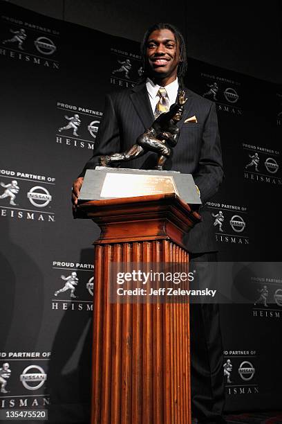 Robert Griffin III of the Baylor Bears poses with the trophy after being named the 77th Heisman Memorial Trophy Award winner during a press...