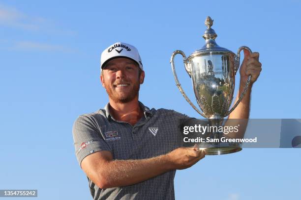 Talor Gooch of the United States celebrates with the trophy on the 18th green after winning during the final round of The RSM Classic on the Seaside...