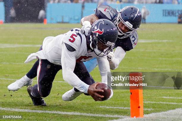 Tyrod Taylor of the Houston Texans dives into the end zone for a rushing touchdown in the third quarter against Amani Hooker of the Tennessee Titans...