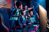 Team of professional cybersport gamers celebrating success in gaming club