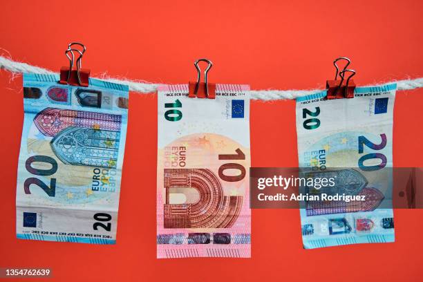 euro bills are hung with clothespins on a string on a red background - 10ユーロ紙幣 ストックフォトと画像