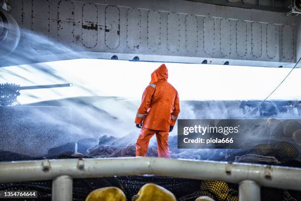 fisherman on a trawler, over a fishing net - kommersiellt fisknät bildbanksfoton och bilder