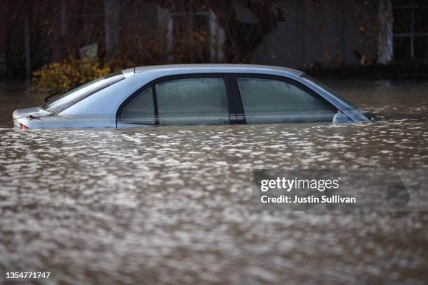 Car sits submerged in floodwaters on November 21, 2021 in Abbotsford, British Columbia. Residents and farmers continue to clean up and recover nearly...