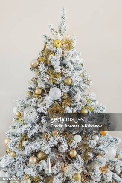 luxury christmas trees with artificial snow decorated with golden and white ornaments. - pracht tanne stock-fotos und bilder