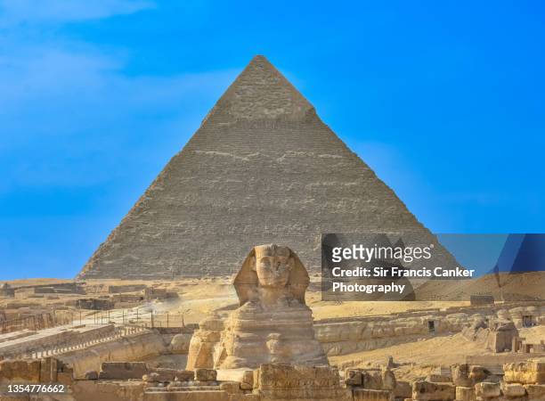 great sphinx of giza (representing pharaoh khafre) and pyramid of khafre aligned with perfect blue sky in cairo, egypt - giza fotografías e imágenes de stock