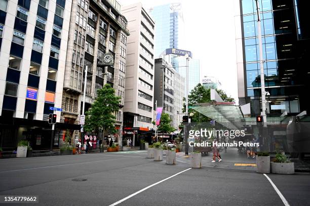 Members of the public cross Queen Street wearing masks on November 22, 2021 in Auckland, New Zealand. Auckland has become this first District Health...