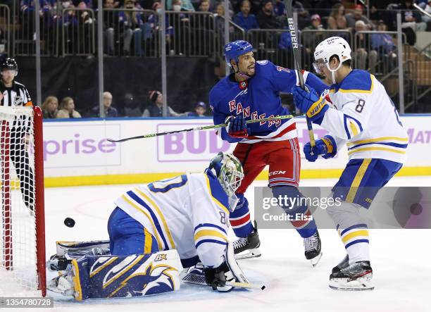 Ryan Reaves of the New York Rangers celebrates teammate K'Andre Miller's goal as Aaron Dell and Robert Hagg of the Buffalo Sabres defend in the...