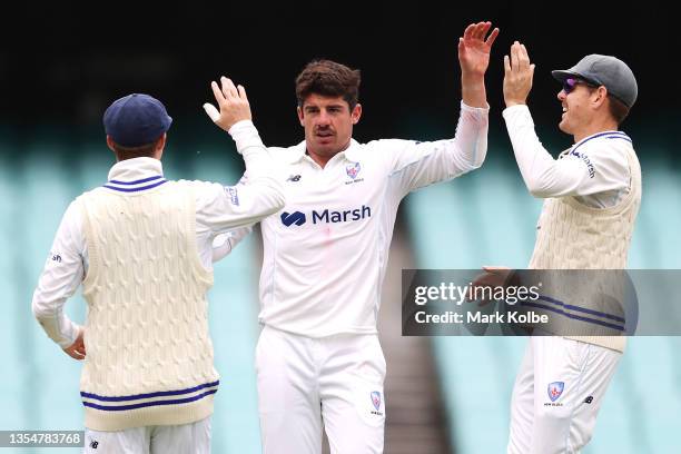 Moises Henriques of New South Wales celebrates with his team mates Matthew Gilkes and Daniel Hughes of New South Wales after taking the wicket of...