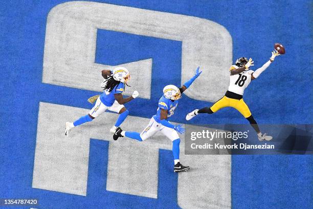 Diontae Johnson of the Pittsburgh Steelers attempts to catch the ball in the endzone as Trey Marshall and Derwin James of the Los Angeles Chargers...