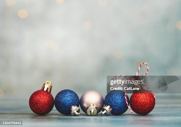 red, white and blue glittery christmas ornaments holiday background with string lights - patriotic christmas stock pictures, royalty-free photos & images