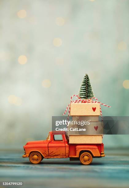 christmas background with toy truck carrying a stack of gifts and a christmas tree. teal background with space for text - christmas truck stock pictures, royalty-free photos & images