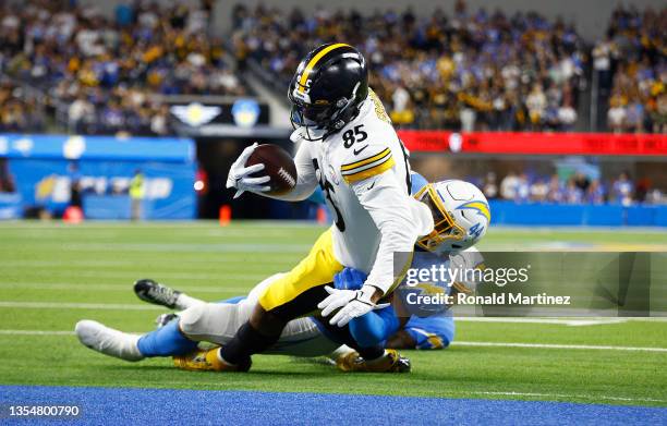 Eric Ebron of the Pittsburgh Steelers scores a touchdown as Kyzir White of the Los Angeles Chargers defends during the fourth quarter at SoFi Stadium...