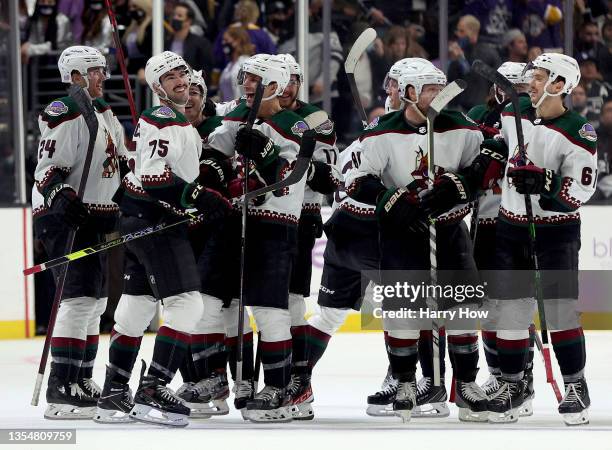 Kyle Capobianco of the Arizona Coyotes celebrates his overtime goal with Antoine Roussel and Hudson Fasching, for a 2-1 win over the Los Angeles...