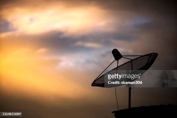 beautiful sunset and silhouetted satellite dish  and copy space - satellite dish foto e immagini stock