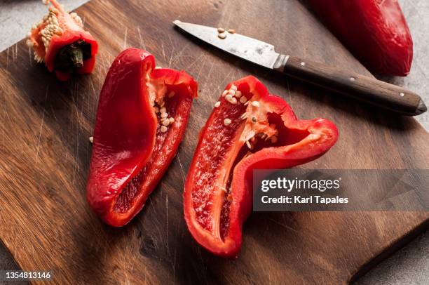 a slice of red bell pepper on a cutting board - pimiento dulce fotografías e imágenes de stock