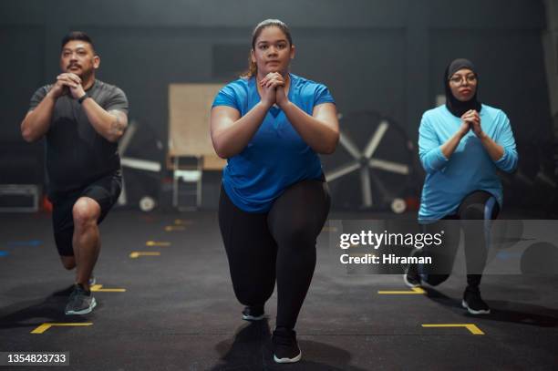 full length shot of a diverse group of people holding a lunge position during their workout in the gym - voluptuous body stock pictures, royalty-free photos & images