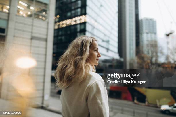 middle-aged woman among high-rise buildings in the city. - center athlete stock pictures, royalty-free photos & images