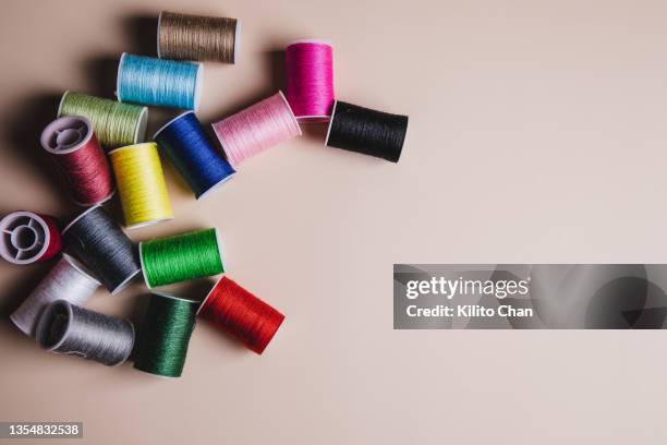 variety of colorful sewing threads against beige background - personalised stock-fotos und bilder