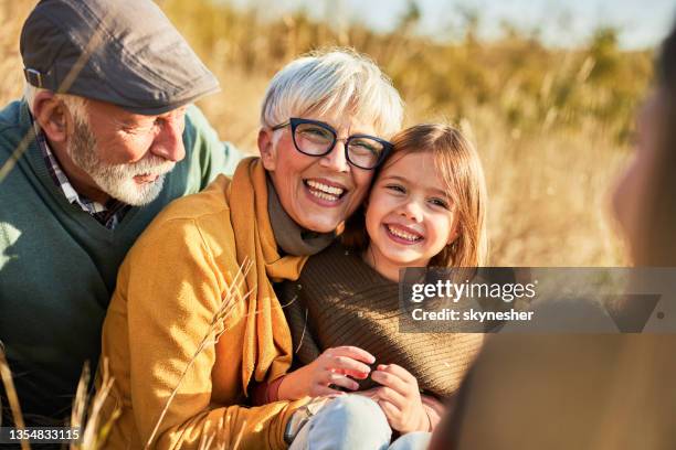nonni felici che si divertono con la loro nipotina nella giornata autunnale. - nonno foto e immagini stock