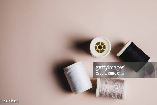 variety of sewing threads against beige background - spool stock pictures, royalty-free photos & images