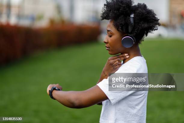 an african woman is checking his heart rate after a training. - taking pulse bildbanksfoton och bilder
