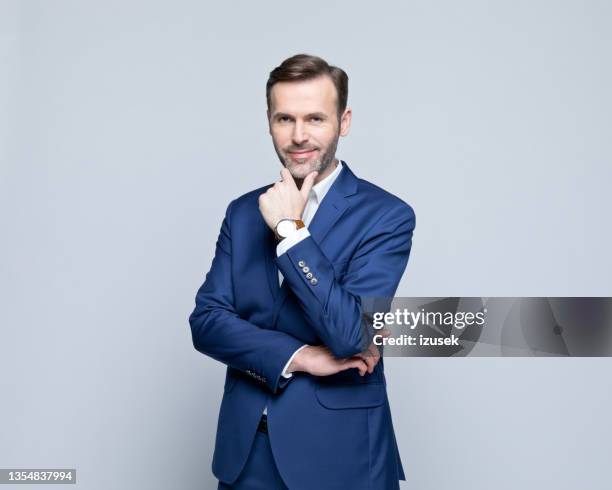 porträt eines freundlichen, reifen geschäftsmannes - blauer anzug stock-fotos und bilder