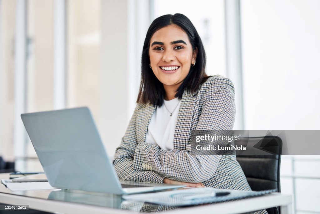 Retrato de una joven empresaria trabajando en una computadora portátil en una oficina