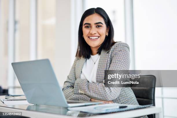 retrato de una joven empresaria trabajando en una computadora portátil en una oficina - indian ethnicity fotografías e imágenes de stock