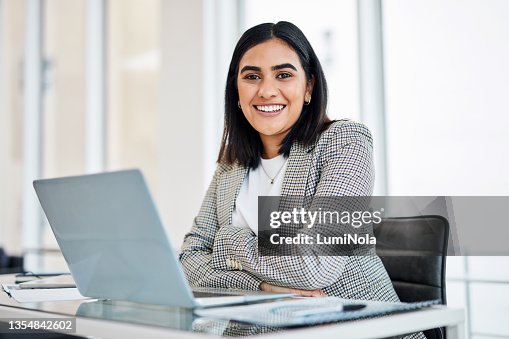 Portrait of a young businesswoman working on a laptop in an office Portrait of a young businesswoman working on a laptop in an office