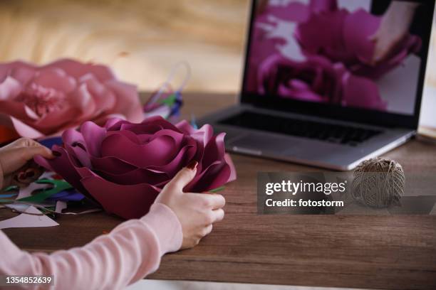 teenage girl following a video tutorial and making paper flowers - paper flower stock pictures, royalty-free photos & images