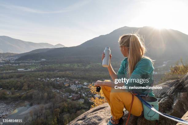 female rock climber takes a moment to enjoy the view - bottled water stock pictures, royalty-free photos & images