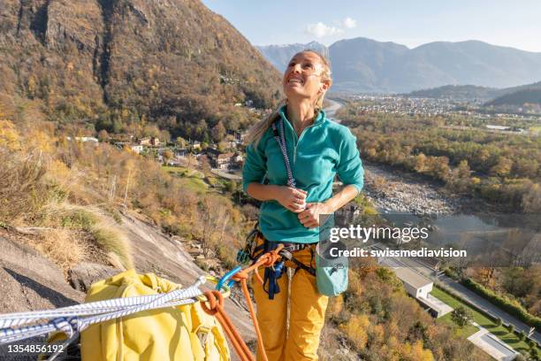 l'alpinista femminile si prepara alla salita della via di arrampicata su roccia - messa in sicurezza foto e immagini stock