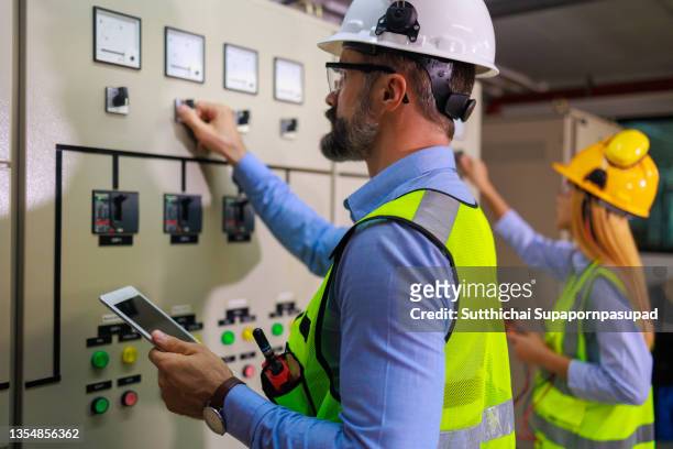 two engineer working with digital laptop at substation electric panel. - electrical panel box stock pictures, royalty-free photos & images