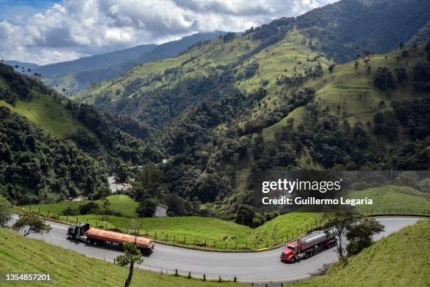 Cargo trucks travel on the road that winds through the mountains during a tour around the 'Cruce de la Cordillera Central' (Central Range Crossroad...