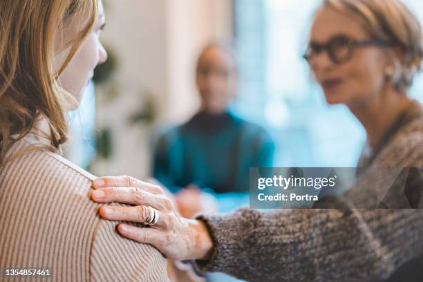 mujer que recibe apoyo psicológico durante la sesión de terapia - terapia de grupo fotografías e imágenes de stock