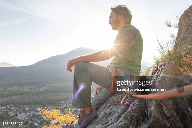 male mountain climber takes a break to enjoy the view - mid adult men stock pictures, royalty-free photos & images