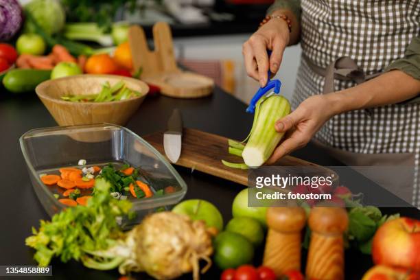 kopieren sie eine weltraumaufnahme einer frau, die eine zucchini für eine mahlzeit schält, die sie zubereitet - geschält stock-fotos und bilder