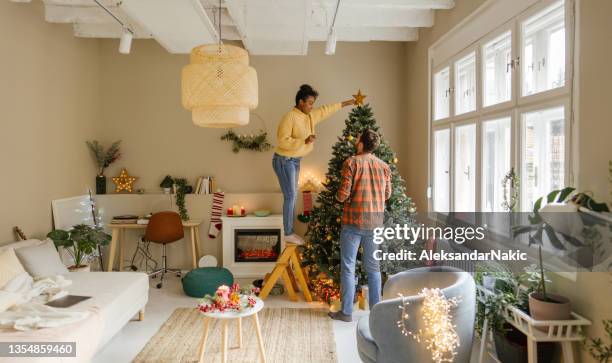 decorating our christmas tree - christmas tree home stock pictures, royalty-free photos & images