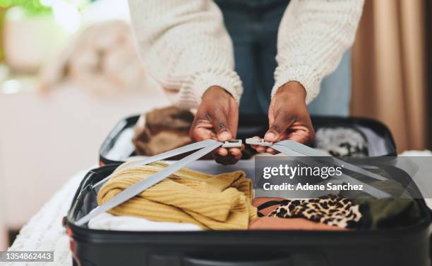 foto recortada de una mujer irreconocible conectando las correas de su maleta antes de partir de vacaciones - neat fotografías e imágenes de stock